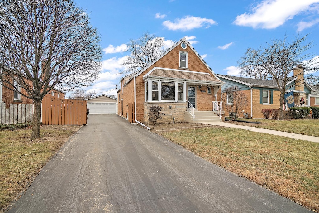 view of front of house featuring an outbuilding, a garage, and a front lawn