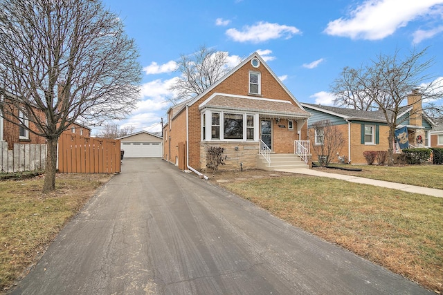 view of front of house featuring an outbuilding, a garage, and a front lawn