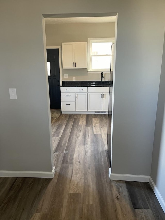 kitchen with dark hardwood / wood-style floors, white cabinetry, and sink