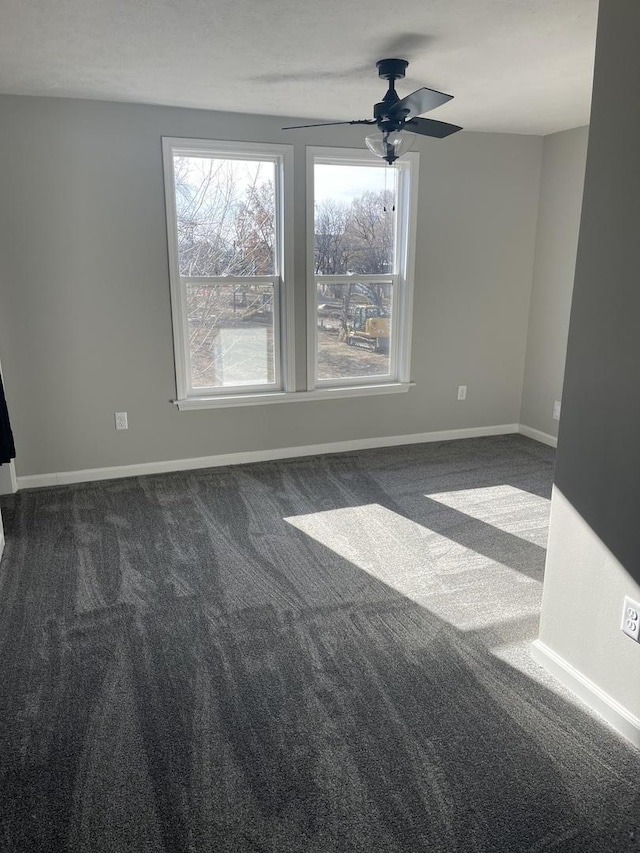 spare room with dark carpet and ceiling fan