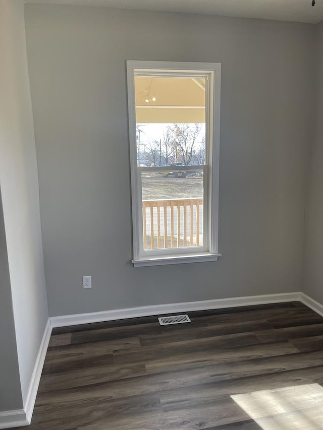 unfurnished room featuring a water view and dark wood-type flooring