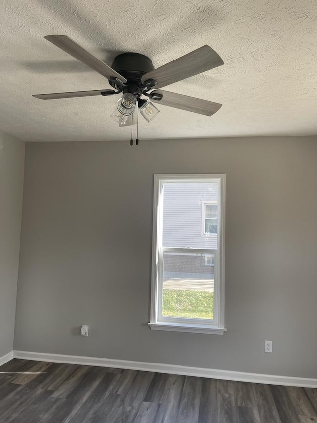 spare room featuring dark hardwood / wood-style floors, ceiling fan, and a textured ceiling