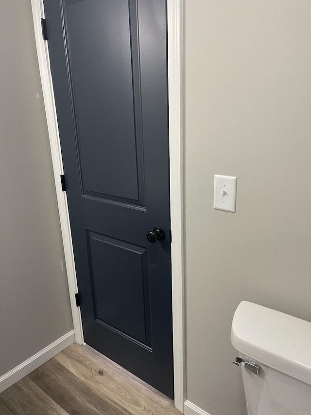 bathroom with toilet and hardwood / wood-style flooring