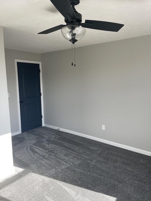 carpeted spare room featuring ceiling fan and a textured ceiling