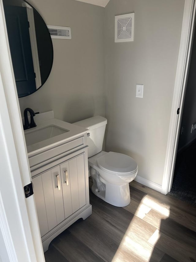 bathroom featuring vanity, wood-type flooring, and toilet