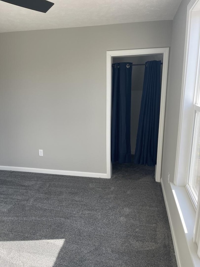 carpeted spare room featuring ceiling fan and a textured ceiling