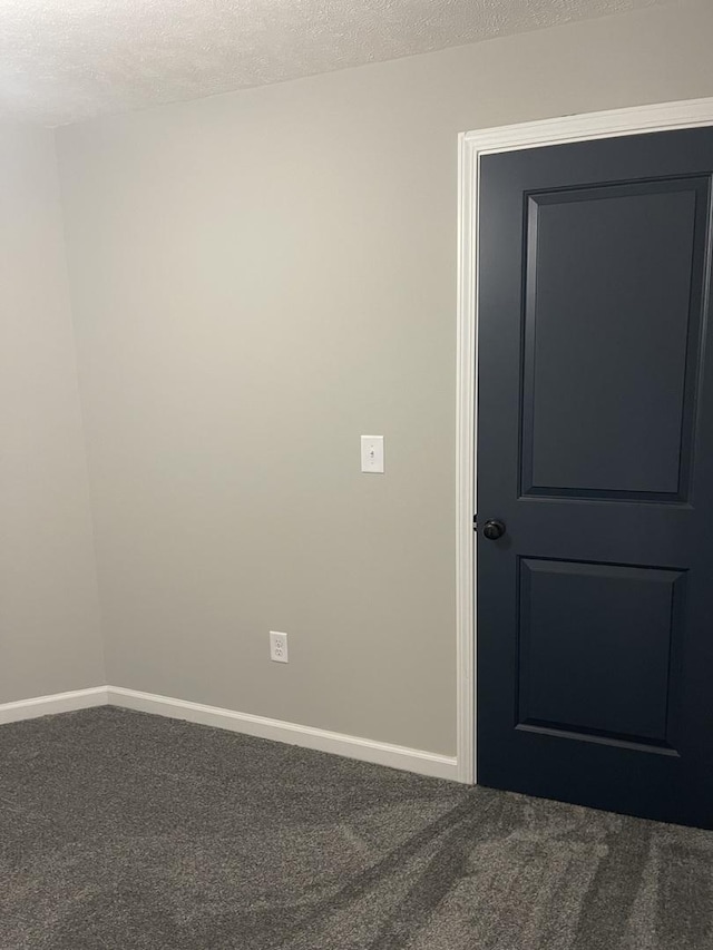 unfurnished room with carpet flooring and a textured ceiling