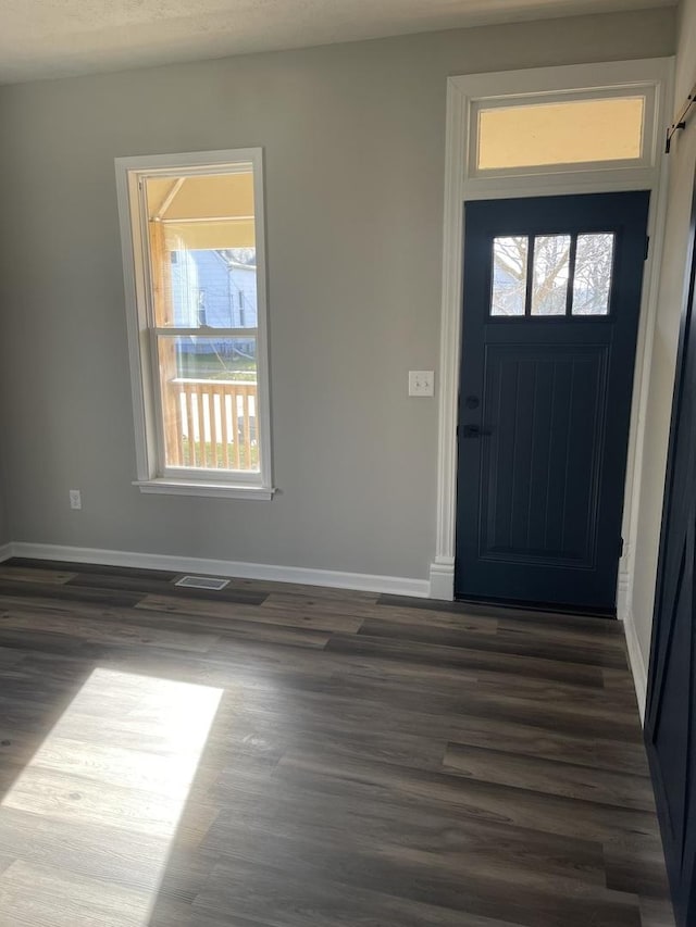 foyer entrance with dark hardwood / wood-style flooring and a textured ceiling