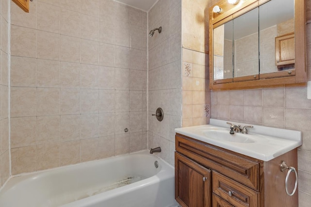 bathroom featuring backsplash, vanity, tiled shower / bath combo, and tile walls