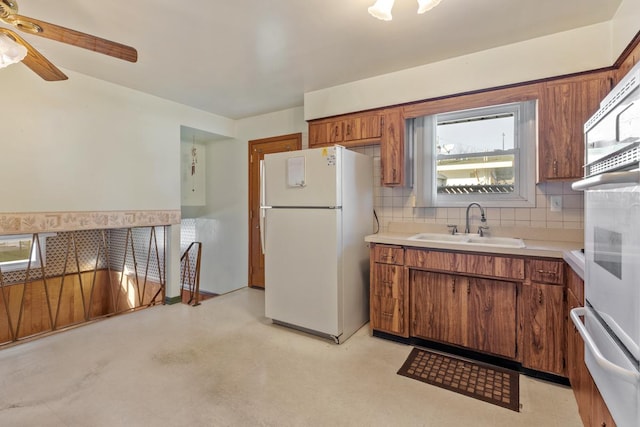 kitchen with tasteful backsplash, ceiling fan, sink, and white appliances