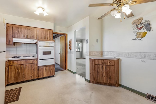 kitchen with decorative backsplash, ceiling fan, and white appliances