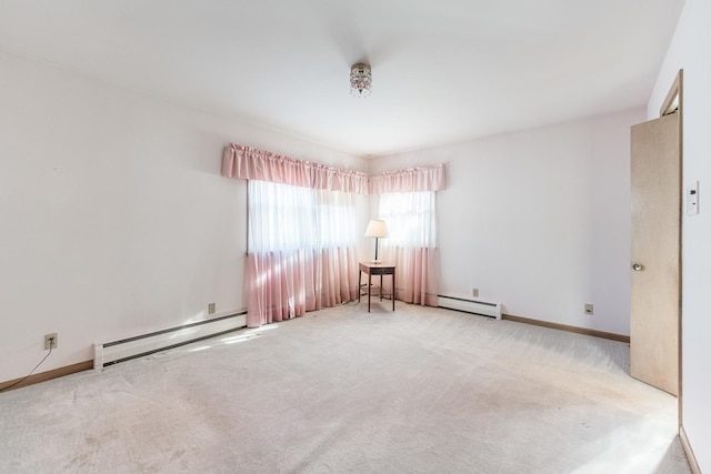 unfurnished room featuring baseboard heating and light carpet