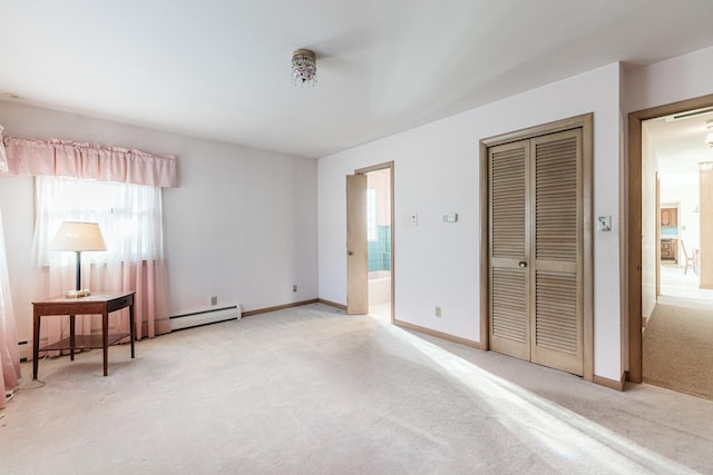 bedroom featuring baseboard heating, ensuite bathroom, a closet, and light carpet