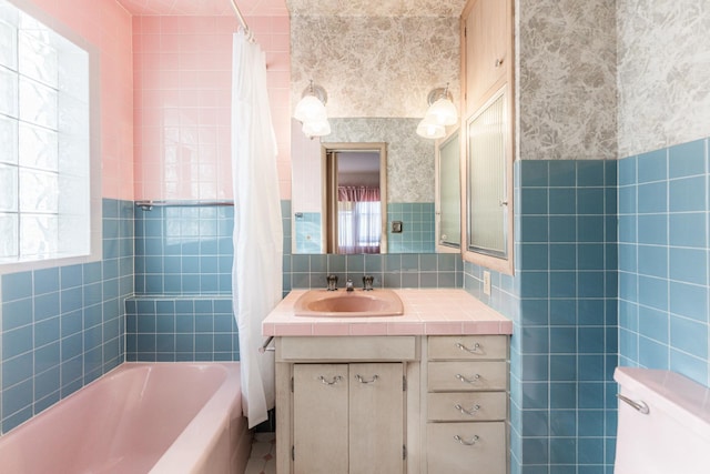 full bathroom with tile walls, toilet, shower / bath combination with curtain, and vanity