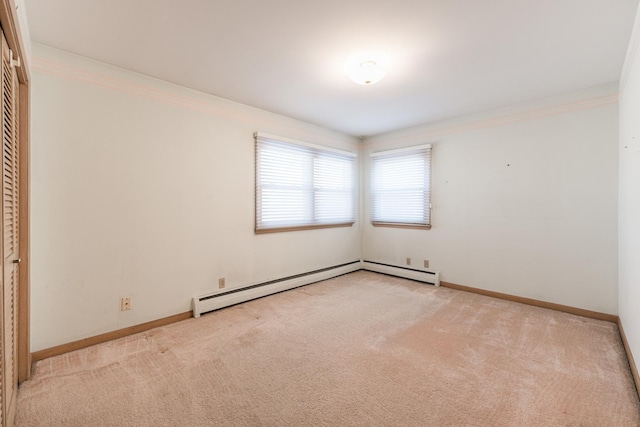 spare room with ornamental molding, light colored carpet, and a baseboard radiator