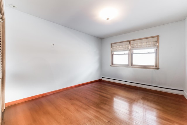 unfurnished room with a baseboard radiator and hardwood / wood-style flooring