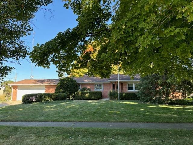 single story home featuring a garage and a front lawn