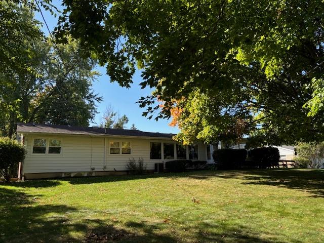 back of property featuring a lawn