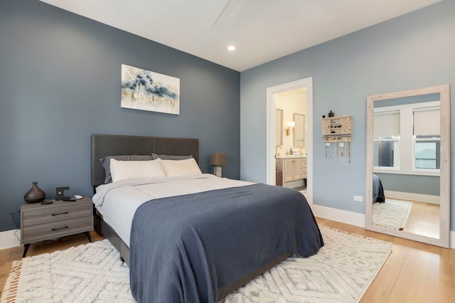 bedroom featuring ensuite bathroom and wood-type flooring