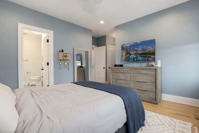 bedroom featuring ceiling fan, light hardwood / wood-style flooring, and connected bathroom