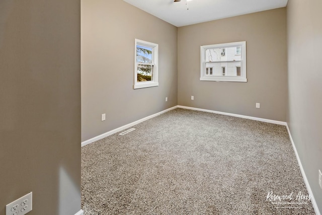 empty room featuring ceiling fan and carpet