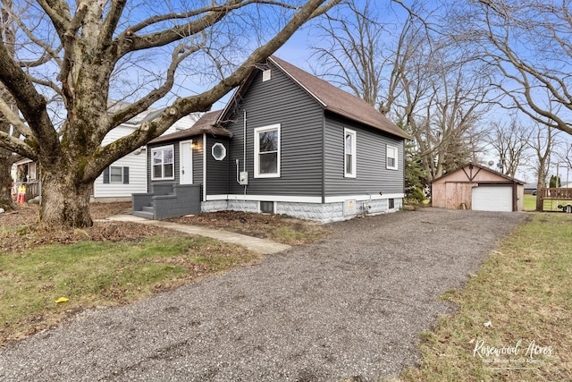 view of front of property featuring a garage, an outbuilding, and a front lawn