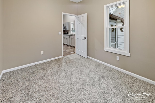 unfurnished bedroom featuring sink and light colored carpet