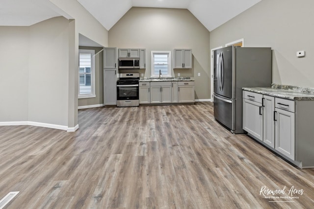 kitchen featuring gray cabinetry, sink, light hardwood / wood-style floors, and appliances with stainless steel finishes