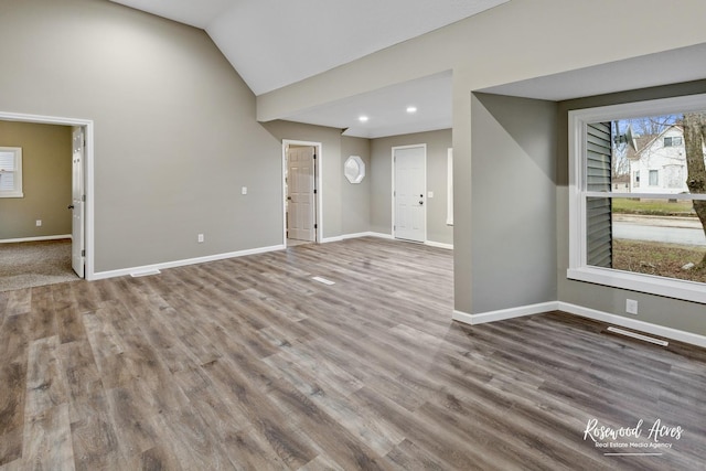 interior space with hardwood / wood-style flooring and lofted ceiling