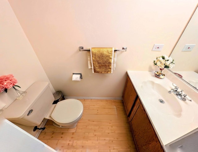 bathroom with hardwood / wood-style floors, vanity, and toilet