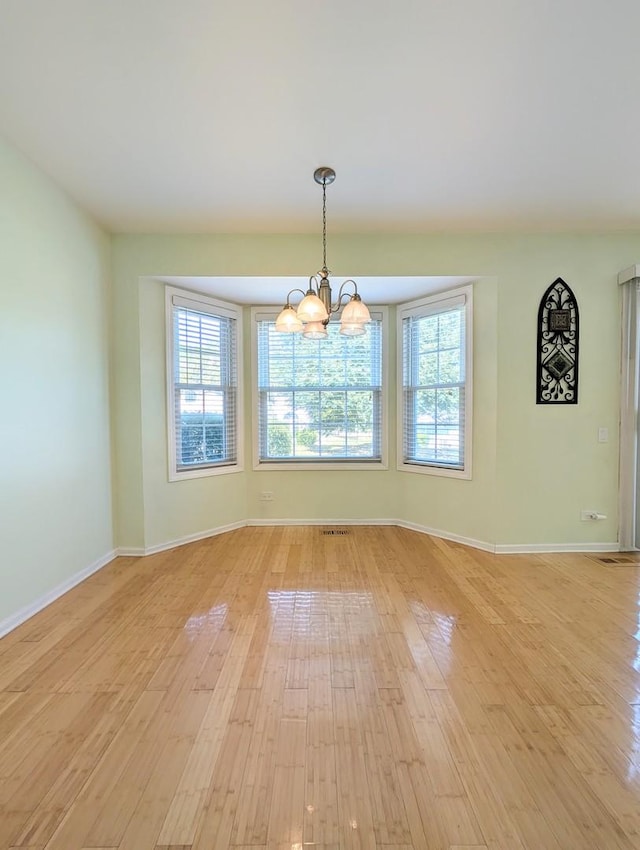 interior space with plenty of natural light, an inviting chandelier, and light wood-type flooring