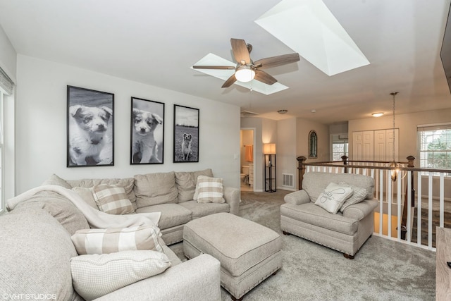 living room featuring carpet flooring, a skylight, and ceiling fan