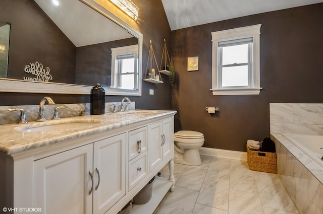 bathroom with lofted ceiling, a wealth of natural light, tiled tub, and vanity