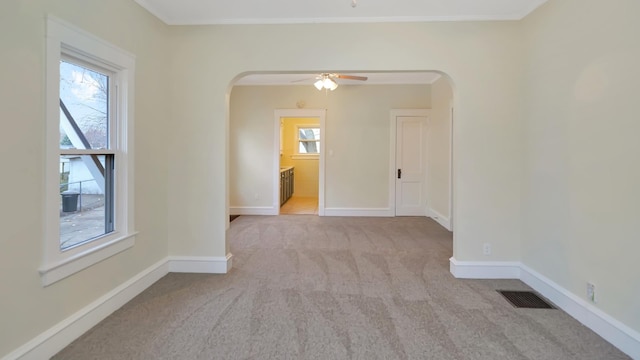 unfurnished room with ceiling fan, ornamental molding, and light carpet