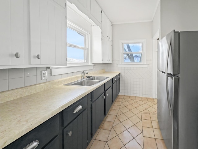 kitchen featuring stainless steel fridge, plenty of natural light, white cabinets, and sink