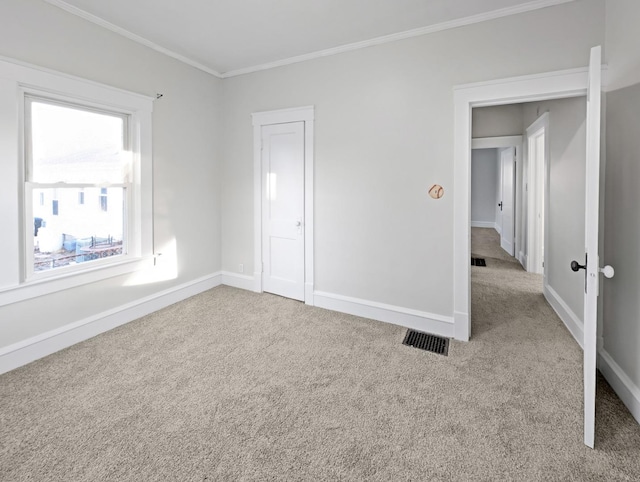 unfurnished bedroom with ornamental molding and light carpet