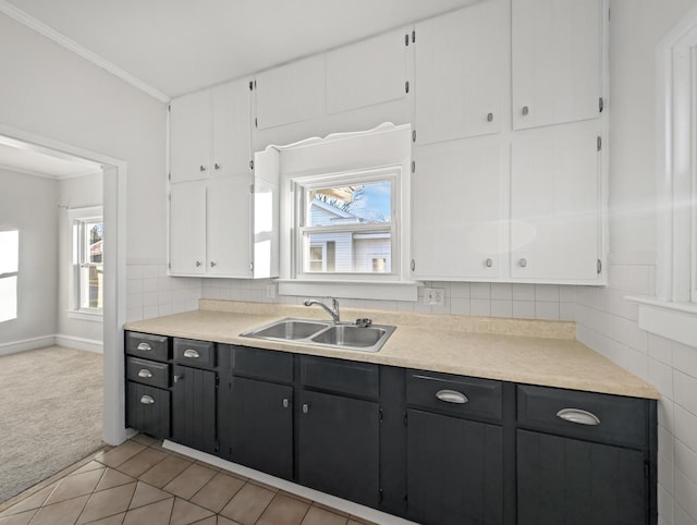 kitchen featuring a wealth of natural light, sink, white cabinets, and light tile patterned floors