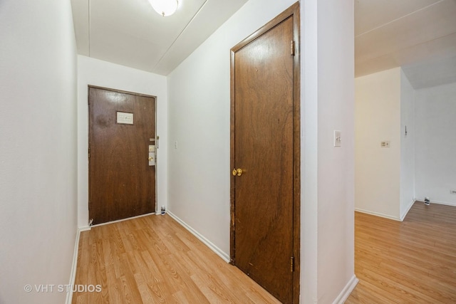 doorway to outside with light wood-type flooring and baseboards