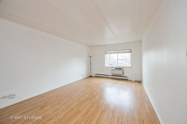 unfurnished room with light wood-style flooring, a baseboard heating unit, baseboards, and a wall mounted AC