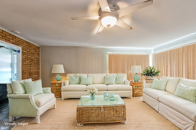 living room with ceiling fan and brick wall