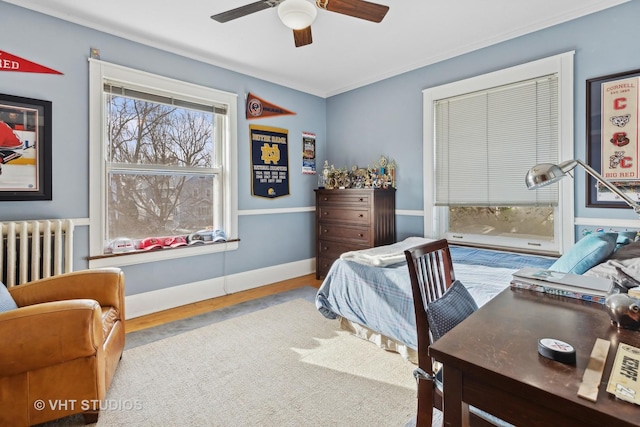 bedroom with ceiling fan, radiator heating unit, and light hardwood / wood-style floors