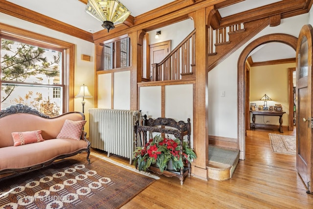 sitting room with radiator, light hardwood / wood-style flooring, and ornamental molding