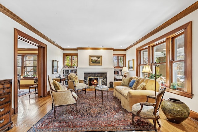 living room with crown molding, plenty of natural light, and light hardwood / wood-style flooring