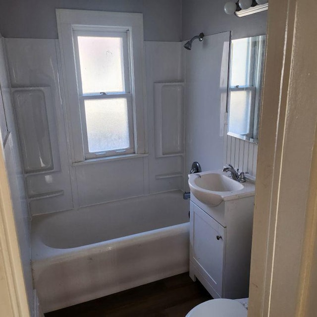 full bathroom featuring wood-type flooring, vanity, shower / bath combination, and toilet