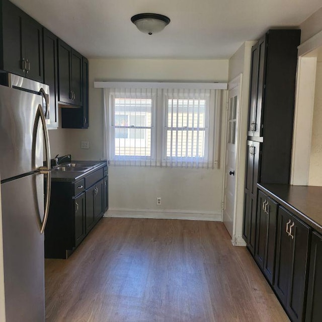 kitchen with stainless steel fridge, sink, and light hardwood / wood-style floors