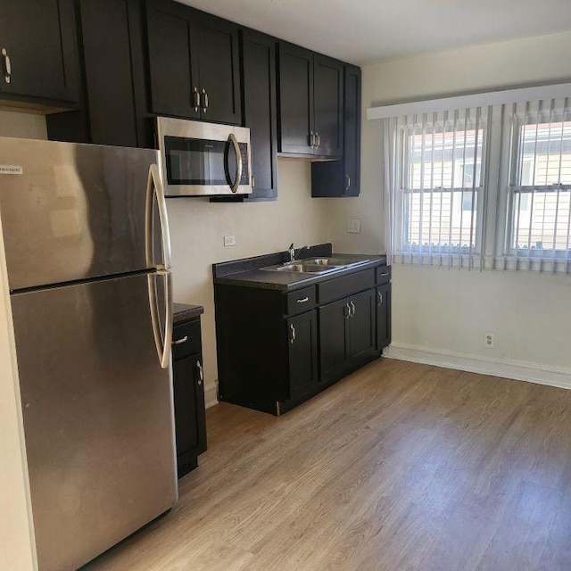 kitchen featuring appliances with stainless steel finishes, light hardwood / wood-style flooring, and sink