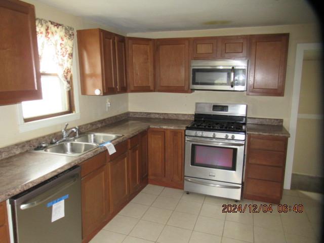 kitchen featuring sink, light tile patterned flooring, and appliances with stainless steel finishes