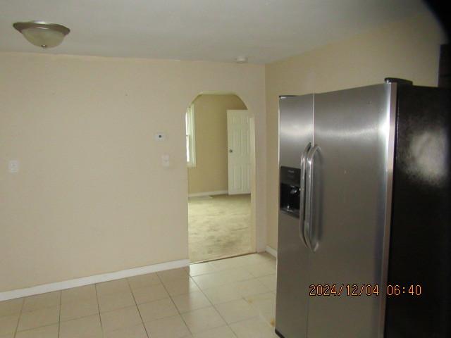 kitchen with stainless steel fridge and light carpet