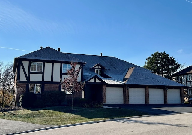 view of front of home with a garage and a front lawn