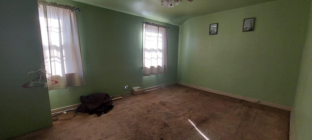 carpeted empty room featuring vaulted ceiling and ceiling fan